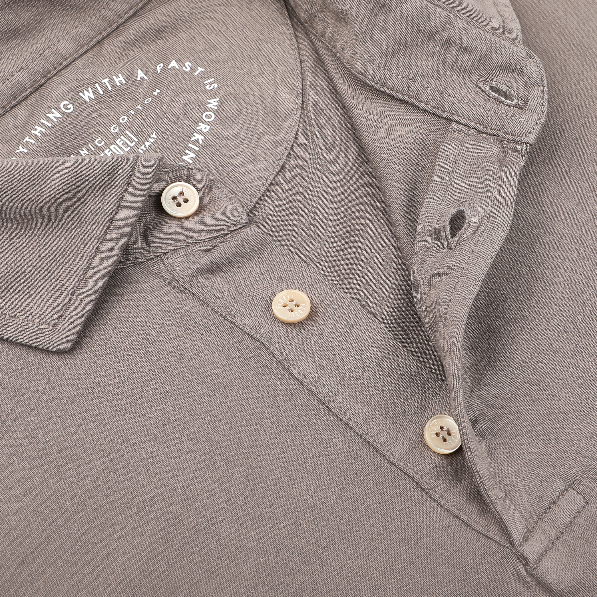 Close-up of the Taupe Beige Organic Cotton LS Polo Shirt by Fedeli, featuring rich Giza cotton and three cream-colored buttons, with printed text inside the collar, exuding luxury casual-wear.