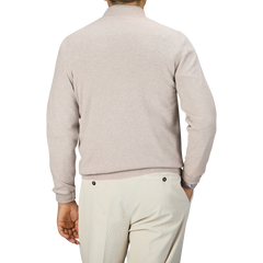 A person wearing a Fedeli Taupe Beige Wool Cashmere 1/4 Zip Sweater and cream-colored pants, viewed from the back.