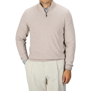 A person is wearing the Fedeli Taupe Beige Wool Cashmere 1/4 Zip Sweater over a blue collared shirt and light-colored trousers. They stand against a plain background, with their face not visible in the image.