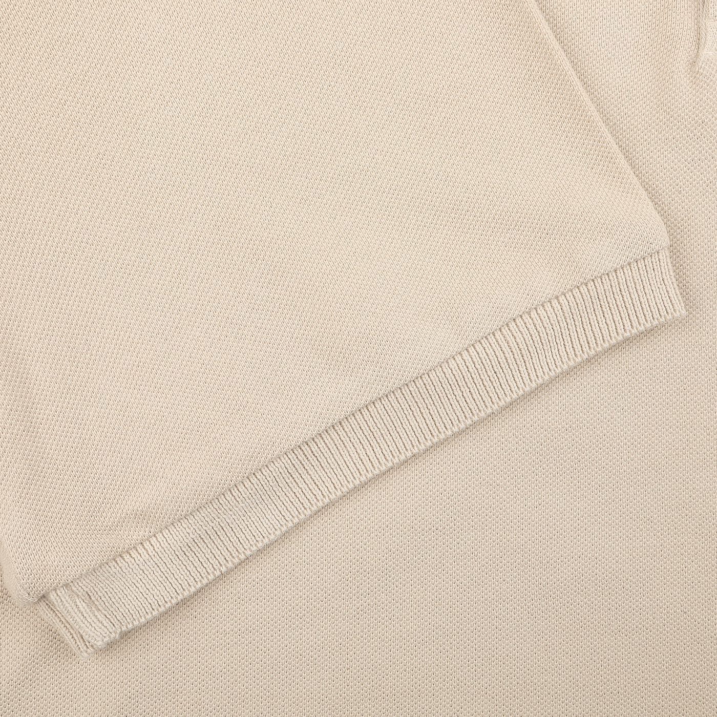 Close-up of Fedeli's Washed Beige Cotton Pique Polo Shirt, showcasing its superior quality knit fabric with cotton pique texture and neatly finished edges.