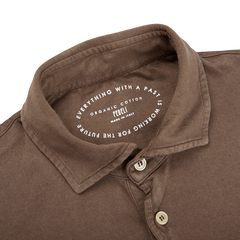 A Washed Brown Organic Cotton LS Polo Shirt by Fedeli with a label on it.