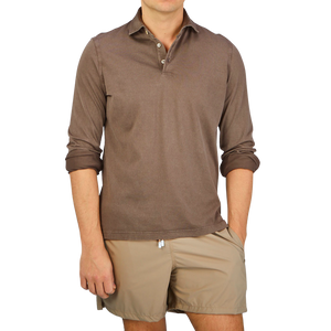 A man wearing a luxury Fedeli Washed Brown Organic Cotton LS Polo Shirt.