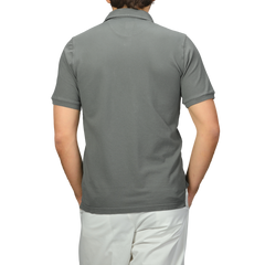 A person is shown from the back in a Fedeli Washed Green Cotton Pique Polo Shirt and white pants against a plain background.