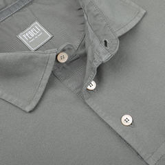 Close-up of a Washed Green Cotton Pique Polo Shirt in textured fabric, showcasing Fedeli's label. This piece embodies superior quality and exudes contemporary sophistication in its design.