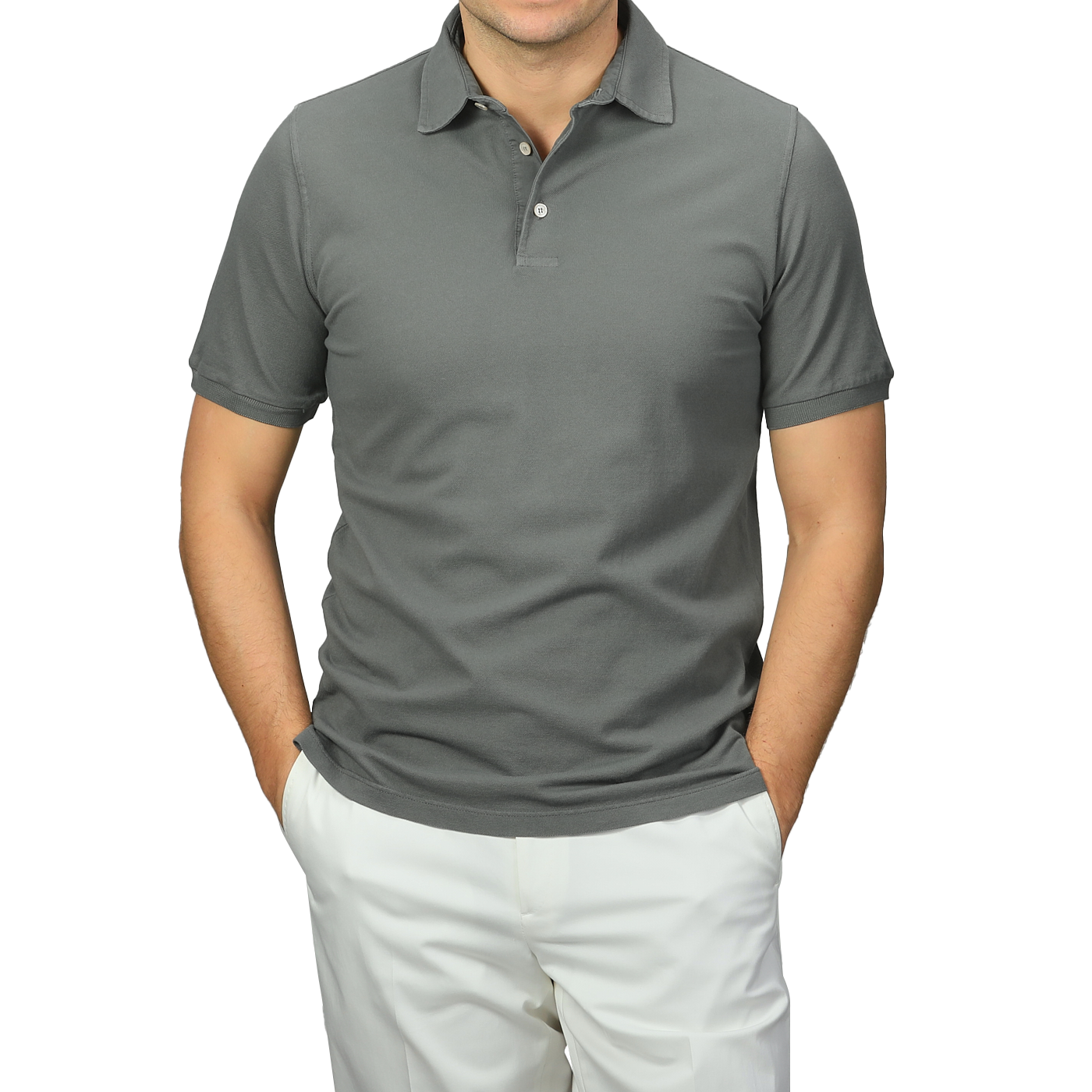 A person stands confidently against a neutral background, wearing a premium Washed Green Cotton Pique Polo Shirt by Fedeli and white pants, hands casually tucked in pockets.