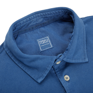 A Fedeli Washed Light Blue Cotton Pique Polo Shirt with a collar.