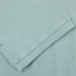 A close up of a Fedeli Washed Light Green Cotton Pique Polo Shirt.