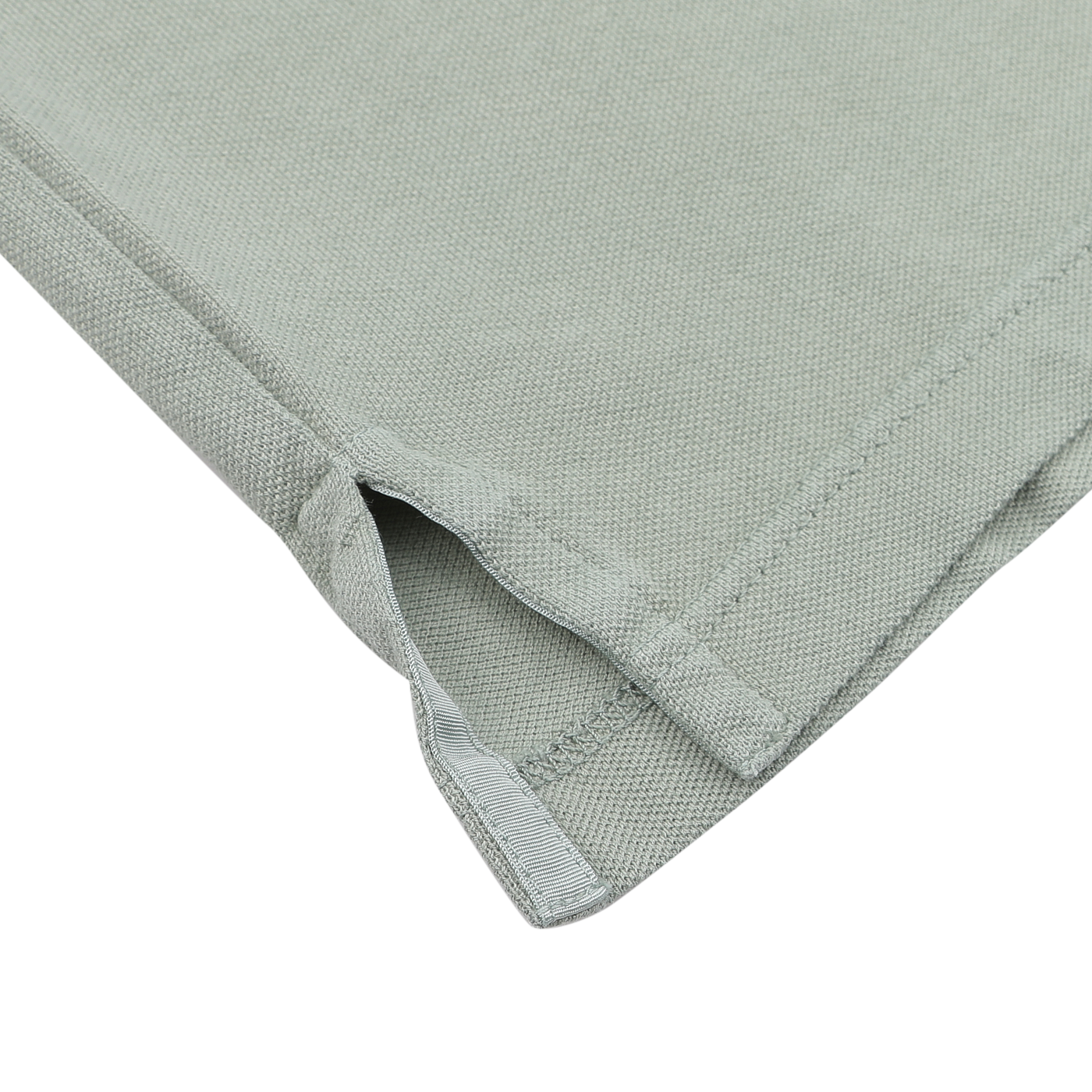 Close-up of a hemmed corner slit on Fedeli's Washed Light Green Cotton Pique Polo Shirt, ideal for elevating your summer wardrobe with its superior quality.