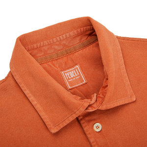 The back of a Washed Rust Cotton Pique Polo Shirt by Fedeli with a label on it.
