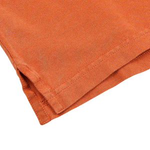A close up of a Fedeli Washed Rust Cotton Pique Polo Shirt.