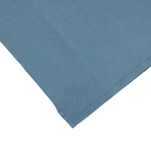 A Fedeli Washed Turquoise Cotton Pique Polo Shirt folded on top of a white surface.