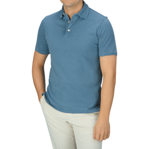 A man wearing a Fedeli Washed Turquoise Cotton Pique Polo Shirt and white pants.