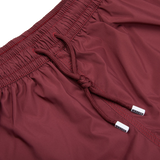 A close up of Fedeli Wine Red Microfiber Madeira Swim Shorts.