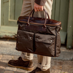 A man is holding a Dark Brown Nylon Leather Shoulder Bag made by Felisi.