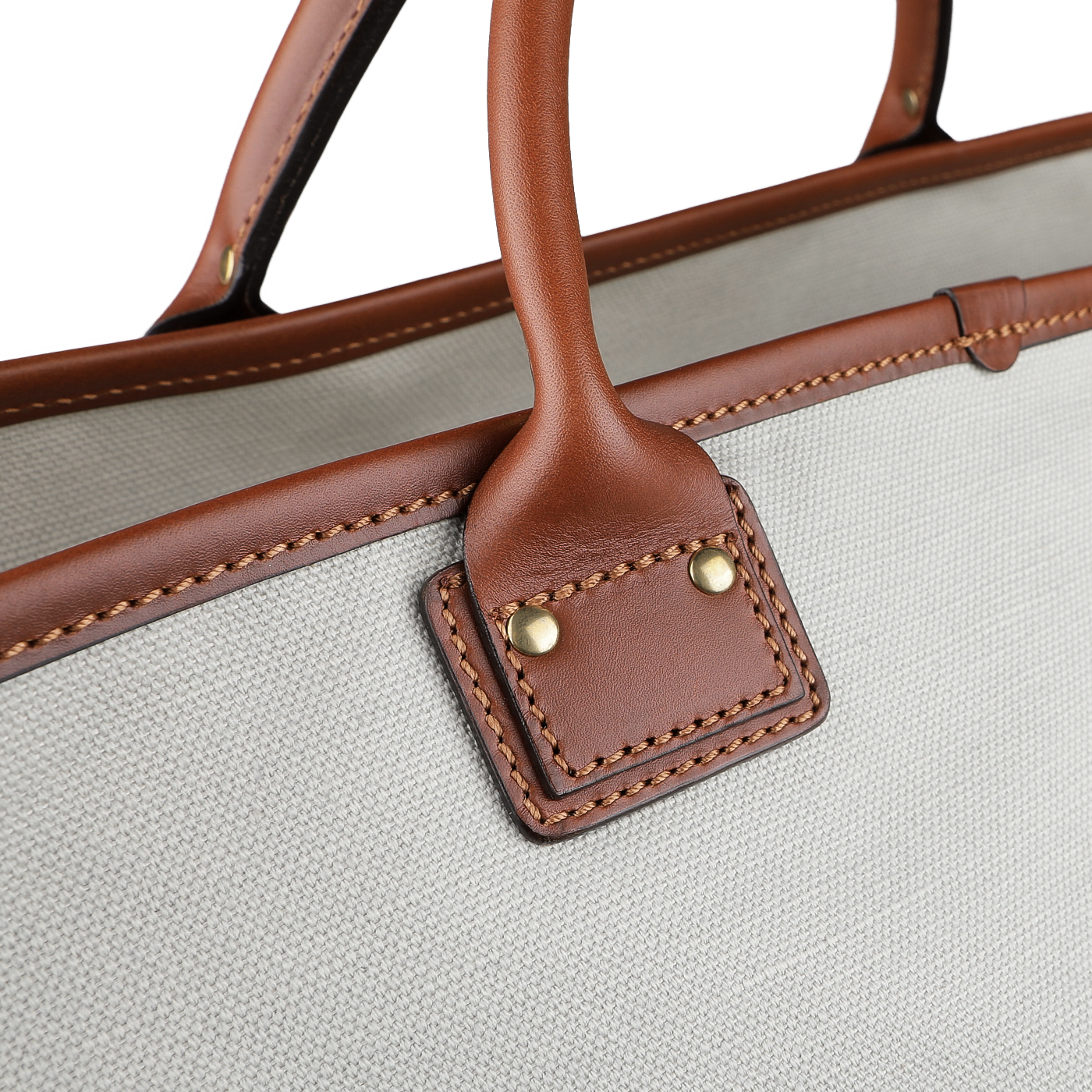 Close-up of the Felisi Navy Grey Cotton Canvas Leather Travel Tote, highlighting its vacchetta calf leather handles and a light gray cotton canvas body, adorned with detailed stitching and brass accents.