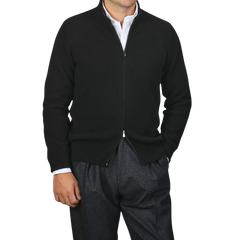 A person wearing a Filippo de Laurentiis Black Cashmere Rib Knit Cardigan over a white shirt and gray pants.