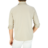 The back view of a man wearing a Filippo de Laurentiis Ciottollo Beige Cotton Jersey Knitted Shirt and white pants.