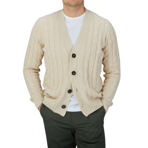 A man wearing a Filippo de Laurentiis Ecru Extrafine Merino Wool Cable Knit Cardigan, showcasing his signature style.