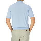 A man viewed from behind wearing a Filippo de Laurentiis Light Blue Crepe Cotton Polo Shirt and beige trousers.