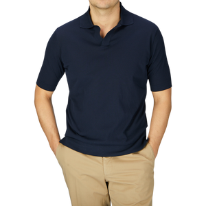 A man in a slim fit Filippo de Laurentiis navy blue Crepe Cotton Polo Shirt and beige trousers stands against a light gray background, with the frame cropped at his neck and knees.