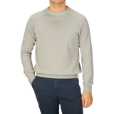 A man wearing a Filippo de Laurentiis Nebbia Grey Crepe Cotton Crew Neck Sweater and blue pants.