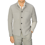 A man wearing a Filippo de Laurentiis Nebbia Grey Crepe Cotton Field Jacket and grey pants.