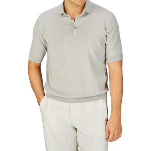Man wearing a Nebbia Grey Crepe Cotton Polo Shirt, made in Italy by Filippo de Laurentiis, with white pants.