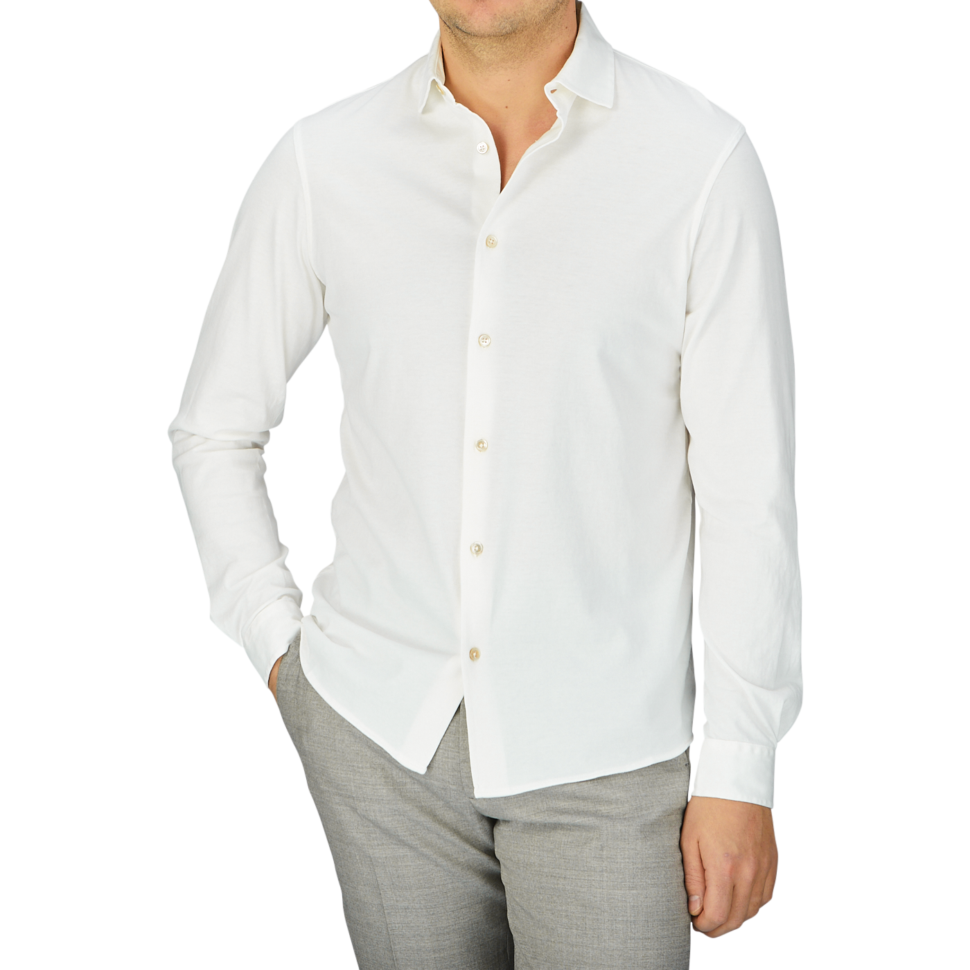 A man wearing a Off White Cotton Jersey Knitted Shirt by Filippo de Laurentiis and grey pants.