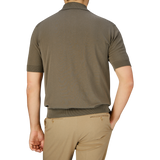 Man seen from the back wearing a seasonal Filippo de Laurentiis olive green crepe cotton polo shirt and beige crepe cotton pants.