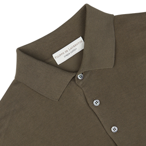 Olive green crepe cotton Filippo de Laurentiis polo shirt with a close-up of the collar and button placket, displaying its designer label.