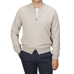 A person wearing a Filippo de Laurentiis Taupe Beige Wool Cashmere Knitted Bomber over a white shirt and navy blue pants stands against a plain grey background.