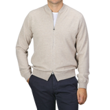 A person wearing a Filippo de Laurentiis Taupe Beige Wool Cashmere Knitted Bomber over a white shirt and navy blue pants stands against a plain grey background.