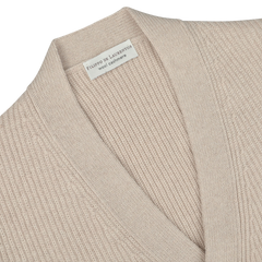 Close-up of the Beige Melange Wool Cashmere Cardigan by Filippo de Laurentiis, made from a blend of beige wool and cashmere. It features a ribbed texture and ribbed hems, with a label that reads "Filippo de Laurentiis.