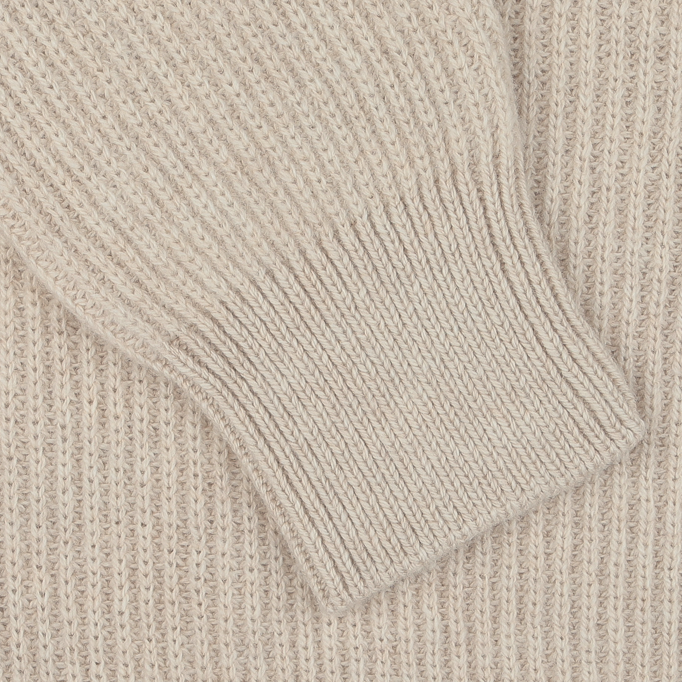 Close-up of the textured fabric of the Beige Melange Wool Cashmere Cardigan by Filippo de Laurentiis, featuring ribbed hems and intricate patterns, crafted from luxurious wool and cashmere, with a sleeve folded over the main body for a seasonal touch.