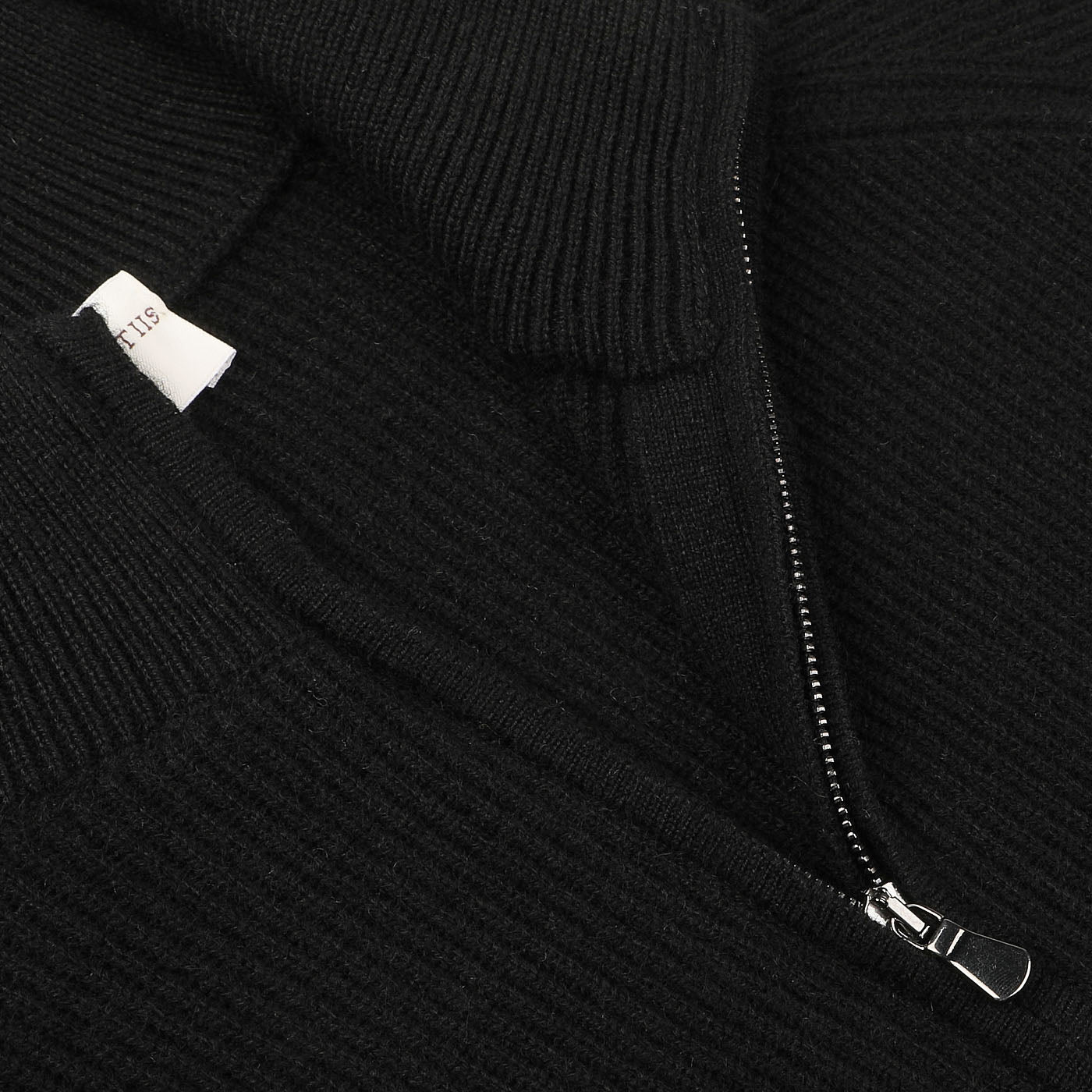 Close-up of the Black Cashmere Rib Knit Cardigan by Filippo de Laurentiis, featuring a zippered front and a visible label at the collar, crafted from pure cashmere.