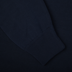 A close up of a Filippo de Laurentiis navy blue crepe cotton crew neck sweater on a black surface.