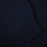 A close up of a Filippo de Laurentiis navy blue crepe cotton crew neck sweater on a black surface.