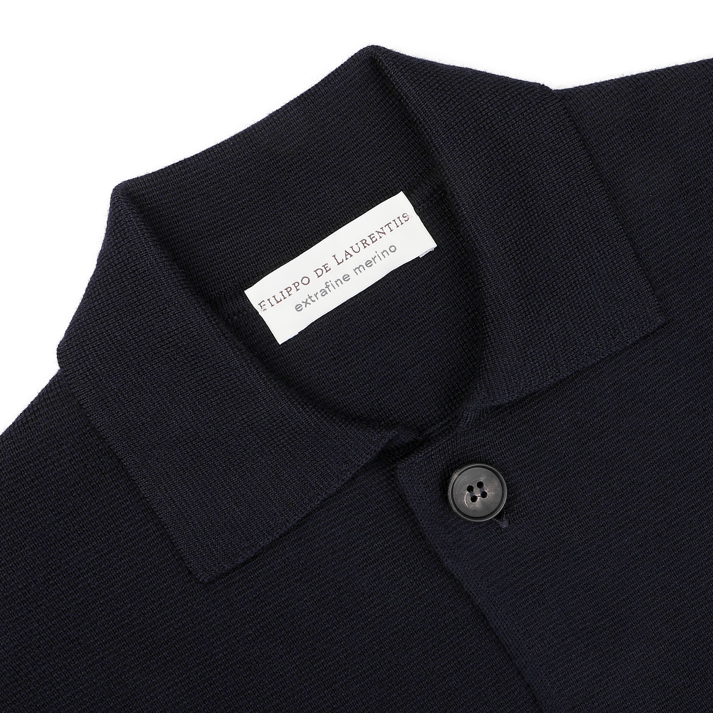 Close-up of a navy blue knit garment crafted from extrafine merino wool, featuring a collar and two buttons. A label inside the collar reads "Filippo De Laurentiis," proudly highlighting its "made in Italy" origin.