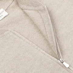 Close-up of the Filippo de Laurentiis Taupe Beige Wool Cashmere Knitted Bomber featuring a metallic zipper partially open, revealing the inner lining. A small tag is visible near the neckline, highlighting the luxurious wool cashmere fabric.