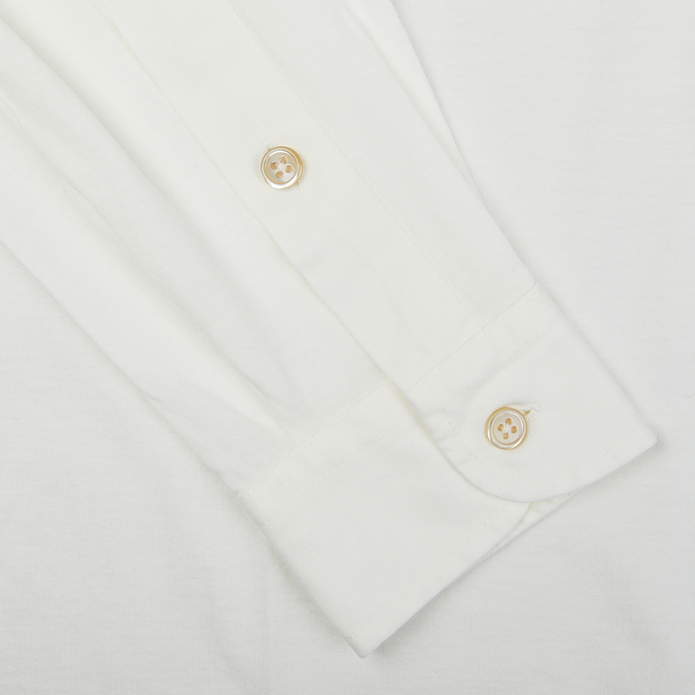 A close up of a Filippo de Laurentiis off white cotton jersey knitted shirt with gold buttons.