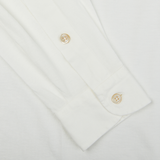 A close up of a Filippo de Laurentiis off white cotton jersey knitted shirt with gold buttons.