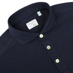 Close-up image of the Blue Melange Cotton Cashmere Jersey Polo Shirt by Finamore, featuring a dark blue, slim fit design with three white buttons and a label inside the collar.