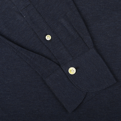 Close-up of the Finamore Blue Melange Cotton Cashmere Jersey Polo Shirt in dark blue, featuring a slim-fit sleeve with a buttoned cuff and two light-colored buttons.