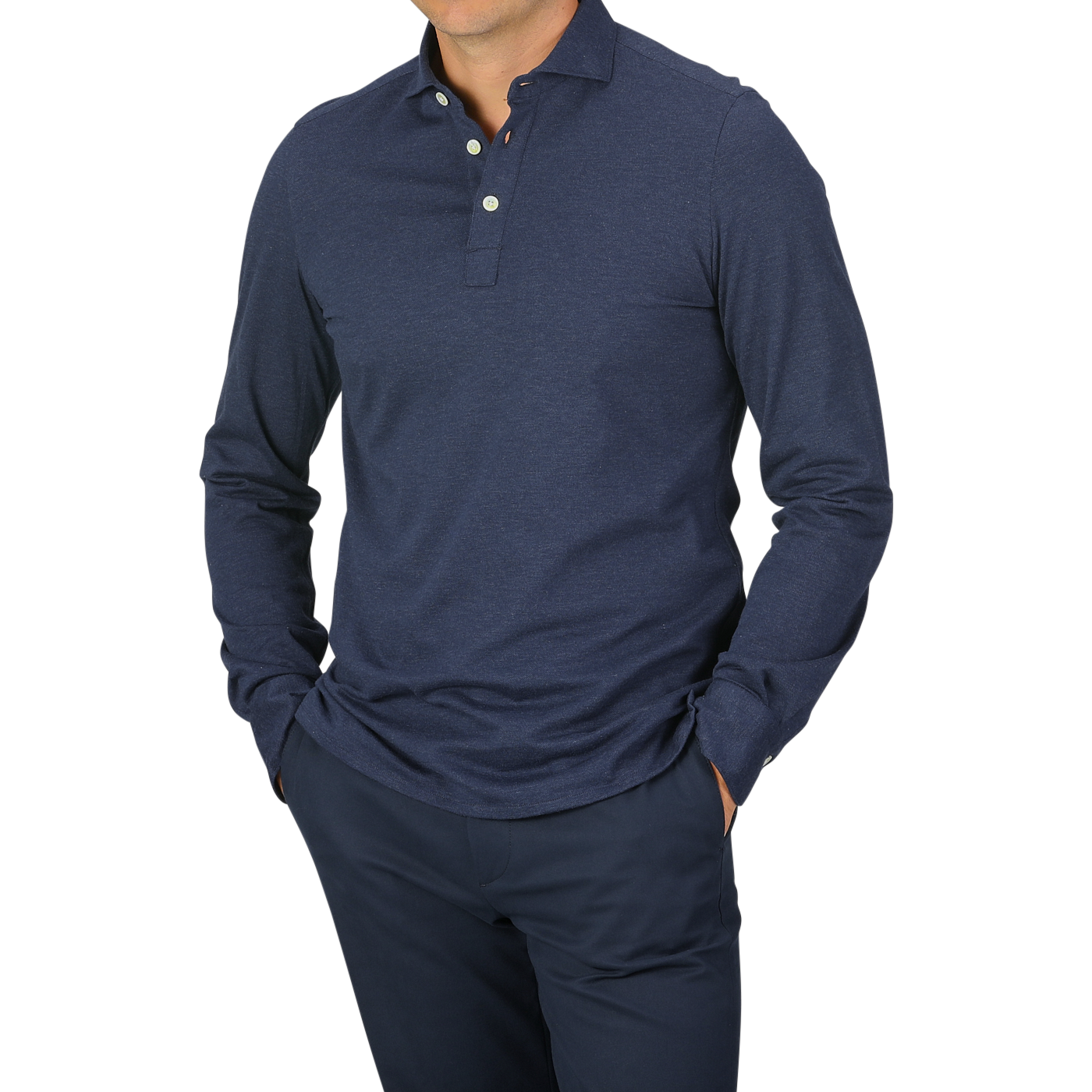 A person dressed in a Blue Melange Cotton Cashmere Jersey Polo Shirt by Finamore and dark pants, standing with hands in pockets. The polo shirt features a buttoned collar. The background is plain and light gray.