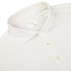 A Finamore Ecru Cotton Cashmere Jersey Polo Shirt, displayed neatly with the top button unfastened. Three buttons are visible on the placket, and the label inside the collar reads "Cotton Cashmere" and "Firenze 495". This slim fit design showcases meticulous craftsmanship.