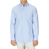 A man in a Finamore Light Blue Washed Cotton Twill Shirt and white pants.