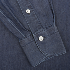 Close-up of a medium blue cotton denim casual shirt cuff featuring two white buttons. The textured fabric highlights the intricate stitching and button details, showcasing the quality of this handmade shirt by Finamore.