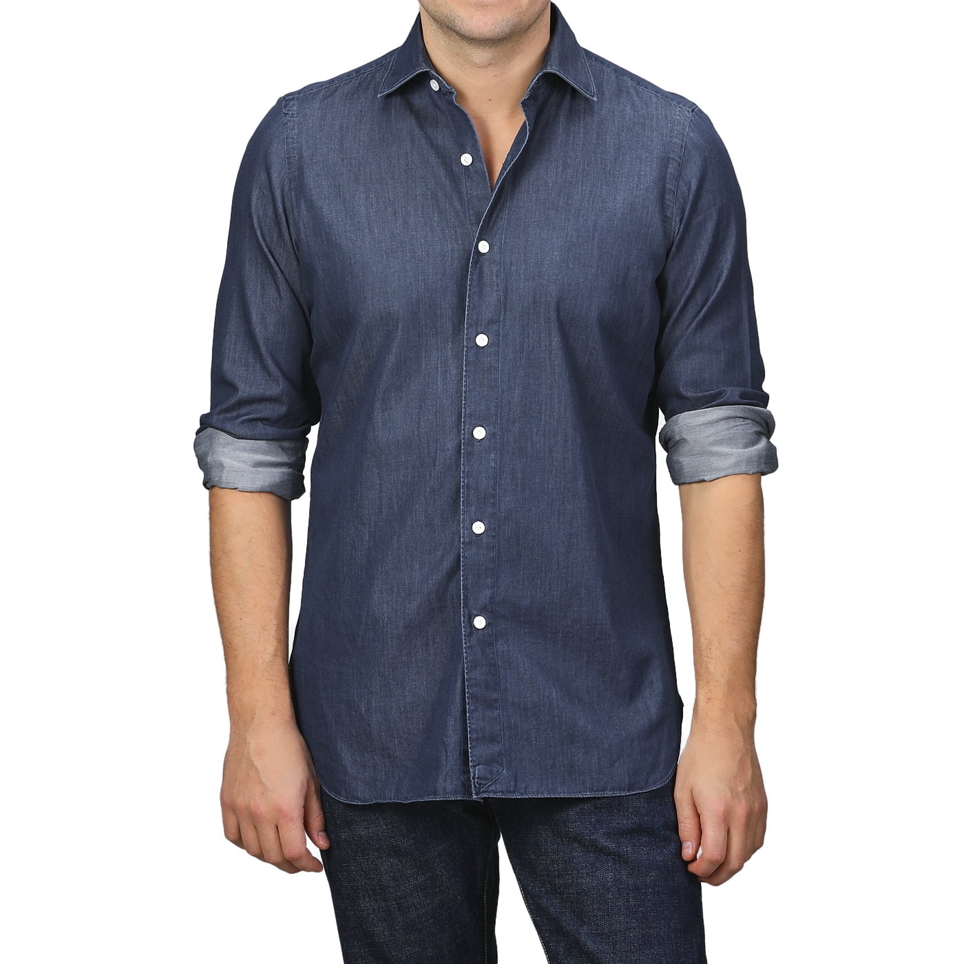 A man dressed in a stylish, fitted Medium Blue Cotton Denim Casual Shirt from Finamore, with rolled-up sleeves, paired flawlessly with dark jeans.