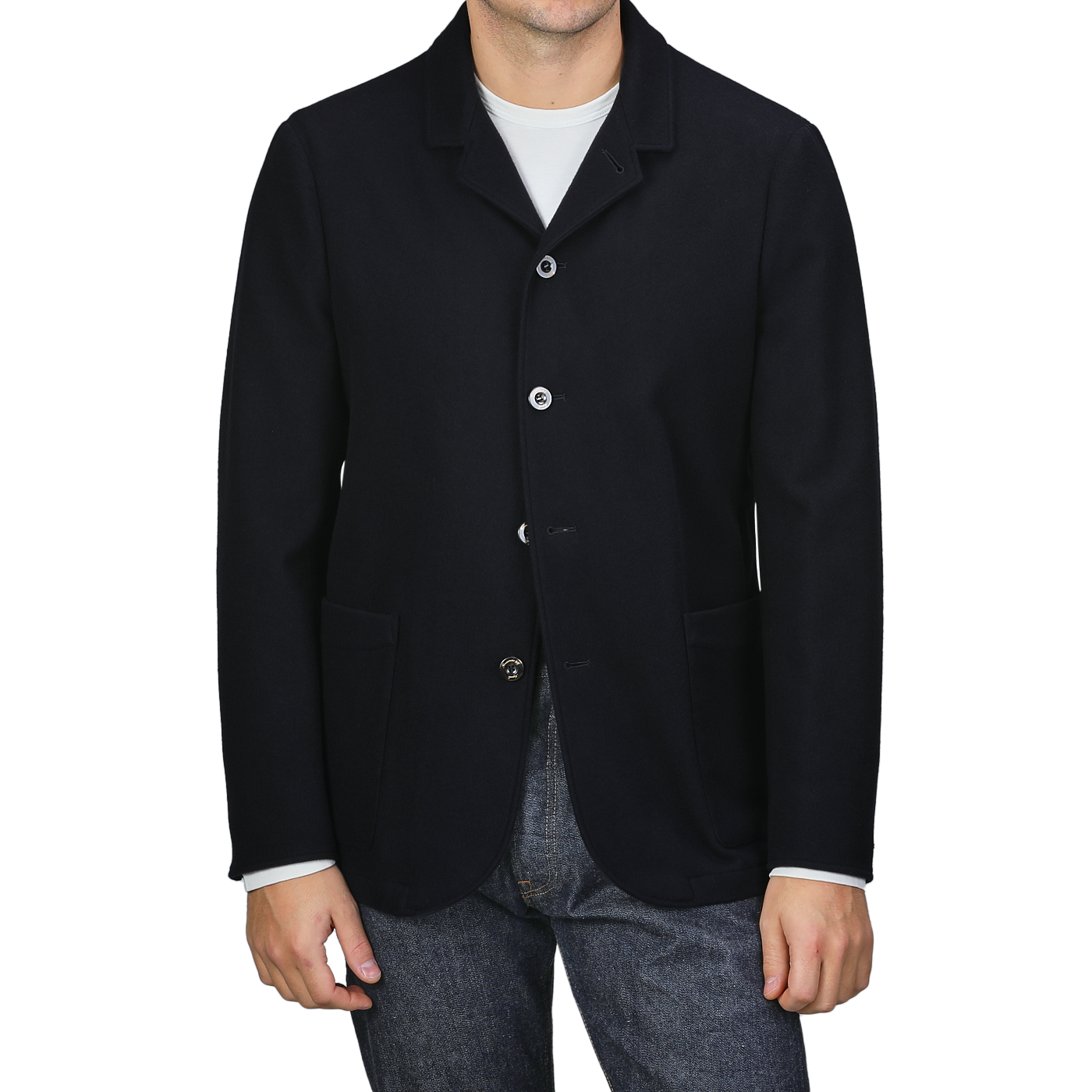 A person is casually dressed in a navy blue boiled wool blazer from Finamore, featuring patch pockets, over a crisp white shirt and jeans.