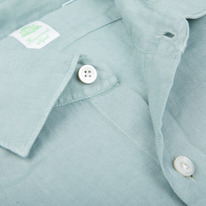 Close-up view of a Finamore Sage Green Linen Casual Shirt with a white button and collar detail.